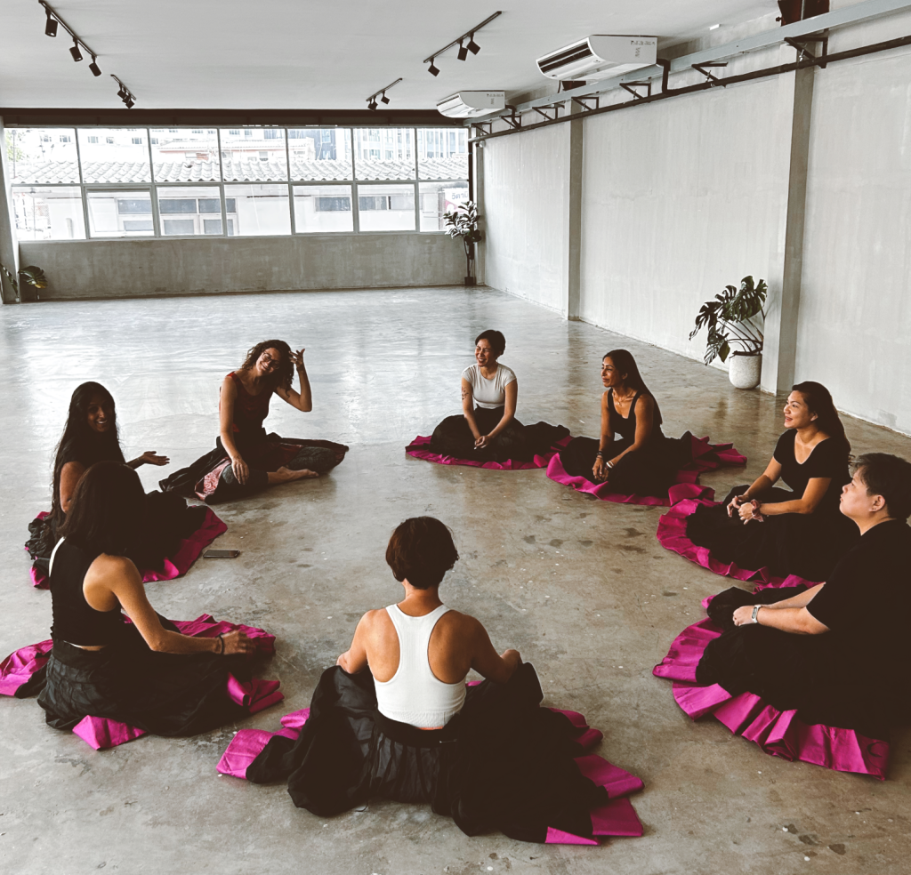 Participants engaging in meditative dance in a serene studio with soft lighting